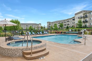 a resort-style swimming pool and hot tub at SoRoc on Maine apartments in Rochester, MN